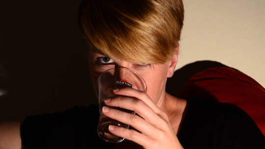 woman taking a drink from a glass